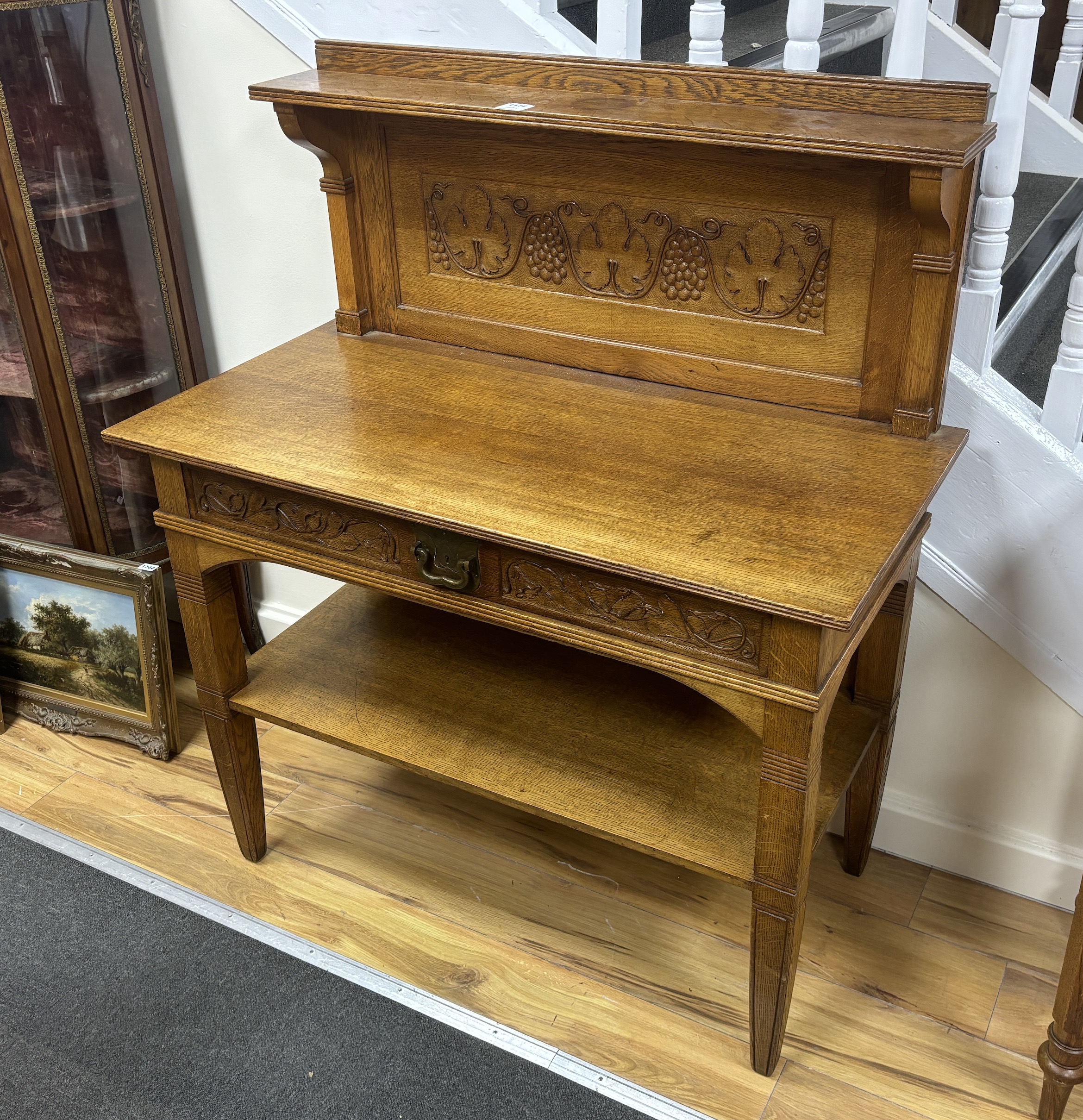 An Arts & Crafts carved oak buffet, width 104cm, depth 52cm, height 123cm